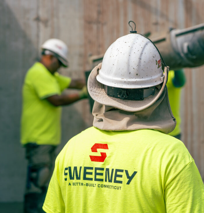 Sweeney, employee facing away towards concrete slide, white hard hat, Sweeney logo on back of t shirt, 24075_BUILDWITT_1471